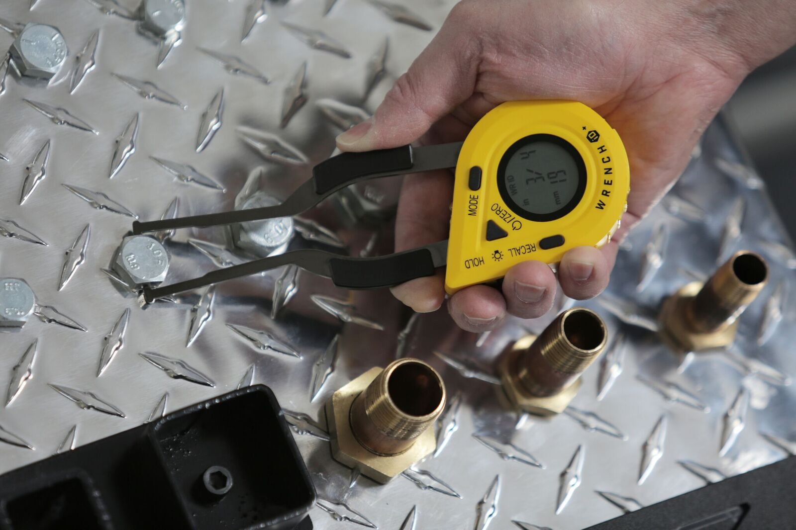The WrenchID being used to measure the size of a bolt.